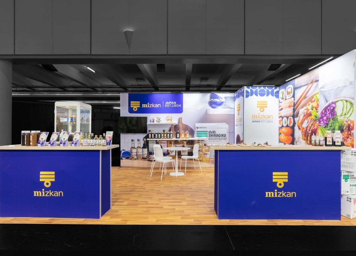 Stand modulaire 21 m² Mizkan SIAL Paris 2026, vue frontale des comptoirs d'accueil – Le Stand Modulaire